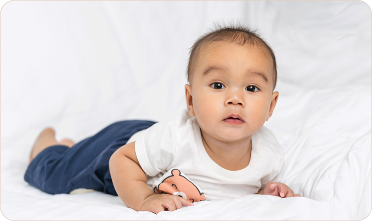 Baby resting on white bedding